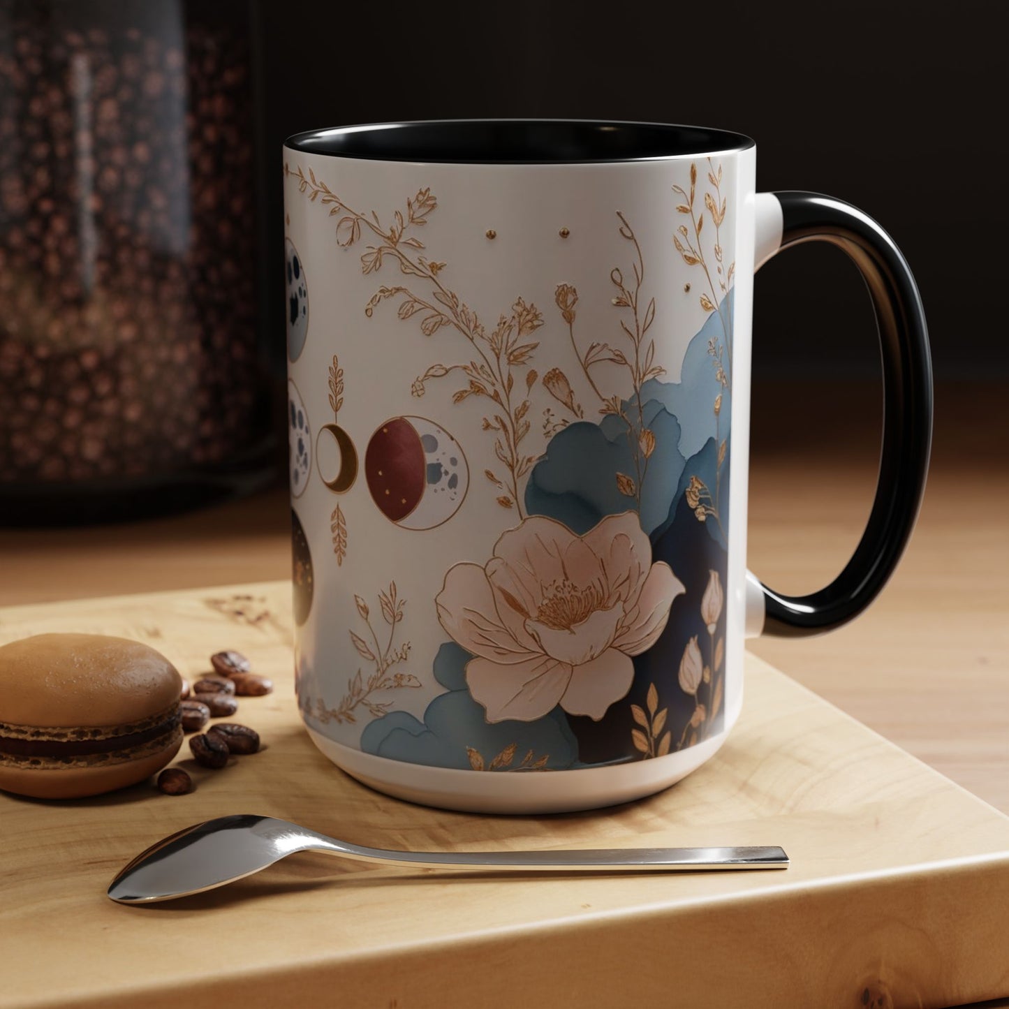 Decorative mug with floral design on a wooden surface with coffee beans and a macaron.