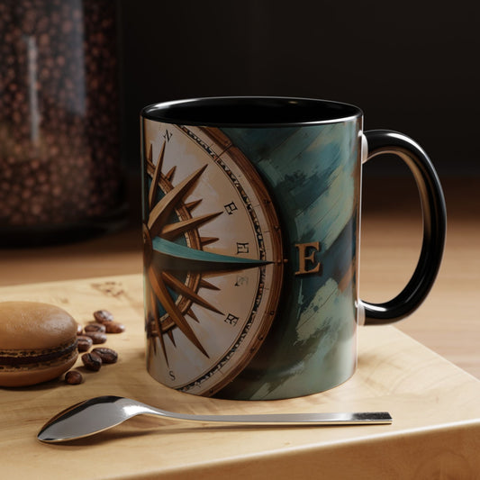 Mug with compass design on a wooden surface with coffee beans and a macaron.