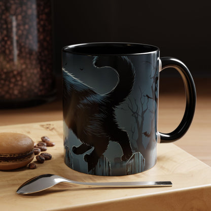 Black mug with a cat design on a wooden surface with coffee beans and a spoon.