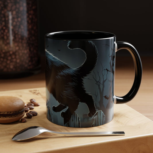 Black mug with a cat design on a wooden surface with coffee beans and a spoon.